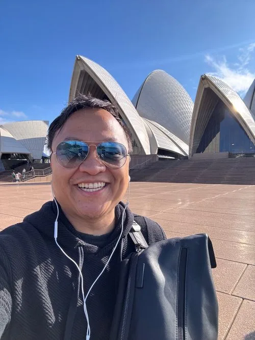 David Hoang standing in Sydney, Australia with city skyline in the background